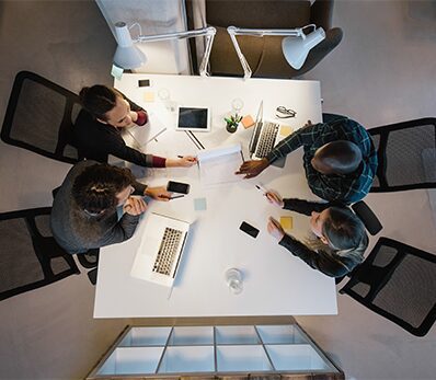 Office workers gather around a table to do research and implement new ideas