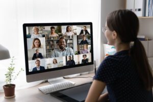 Young freelance employee talking to diverse business team on online virtual conference chat, discussing project with office coworkers on video call. Internet class, webinar screen view